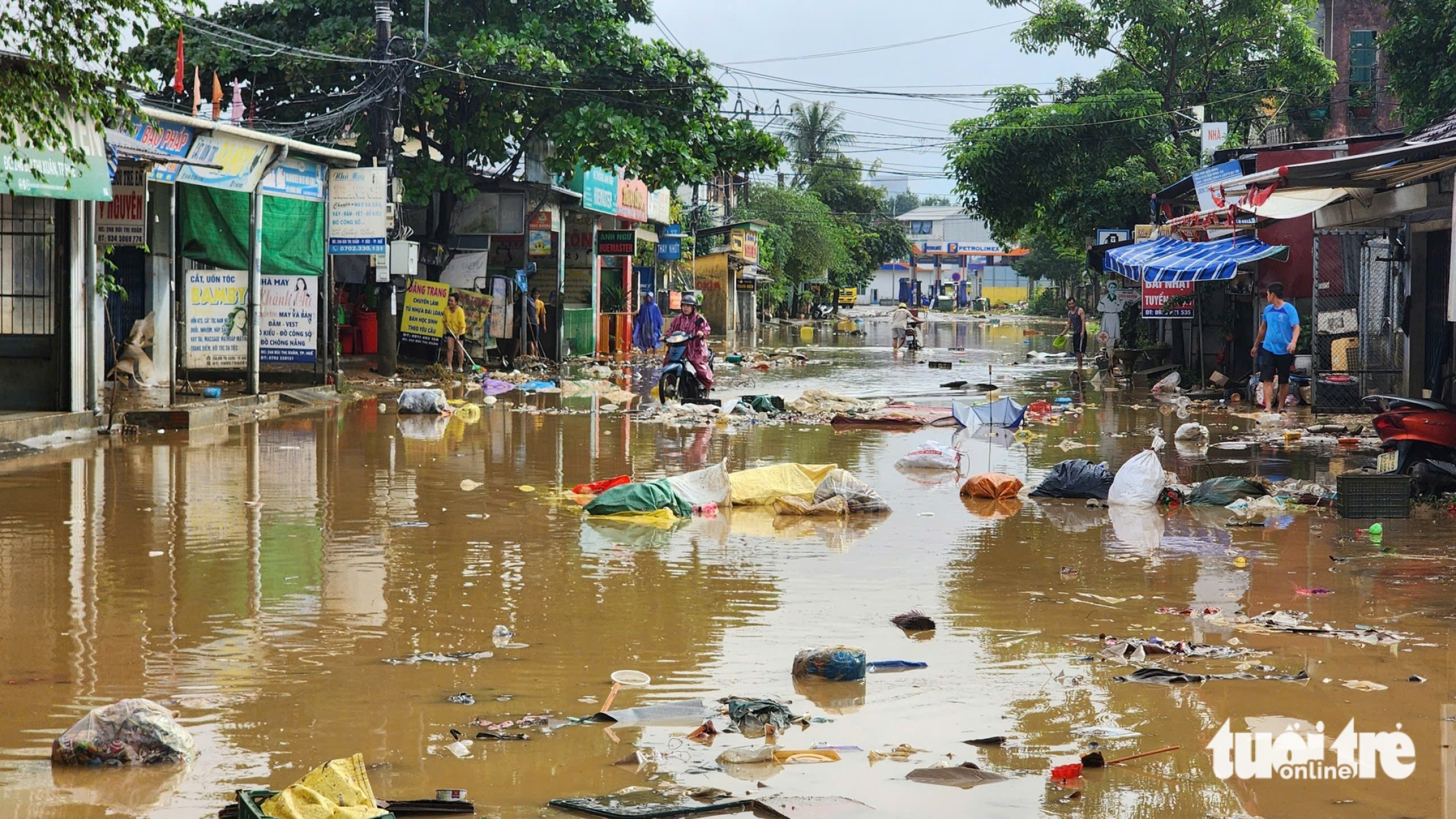 顺化在连续多日大雨后迎来阳光,居民趁洪水退去清理淤泥